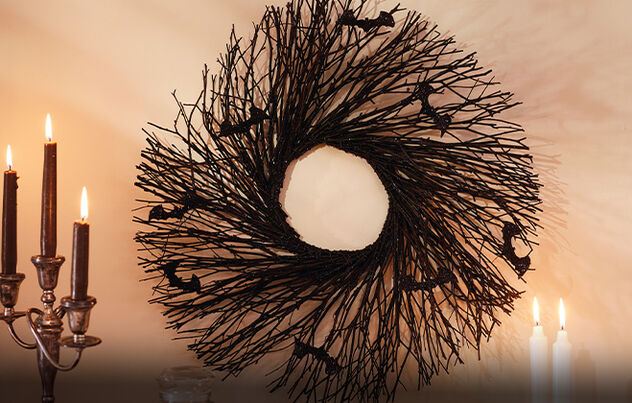 Twig wreath with black bat accents on a wall. 