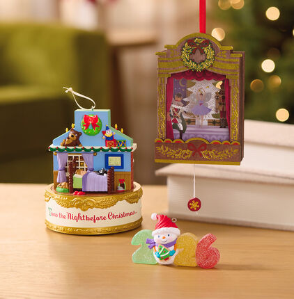 Three holiday themed ornaments on a table.