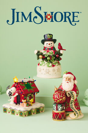 Jim Shore figurines. Snoopy with holiday decorated dog house, snowman in top hat holding a cardinal and garland, and Santa with gifts and 2025 ornament.