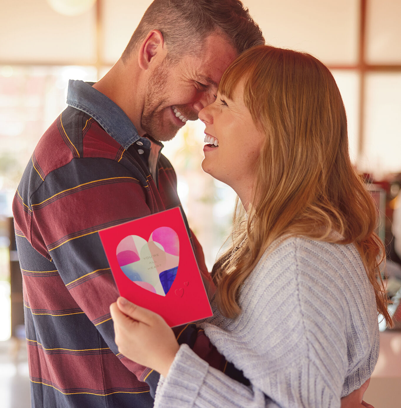 Couple hugging and holding a Valentines Day card