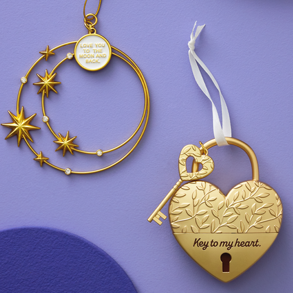 Two golden personalized ornaments on a purple background.