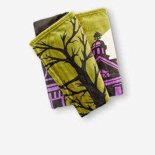 Folded blanket featuring a spindly tree and creepy mansion.