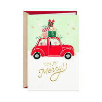 Greeting card with festive design of a puppy in a vintage red convertible loaded with wrapped holiday gifts, shiny gold lettering and sparkly embellishments