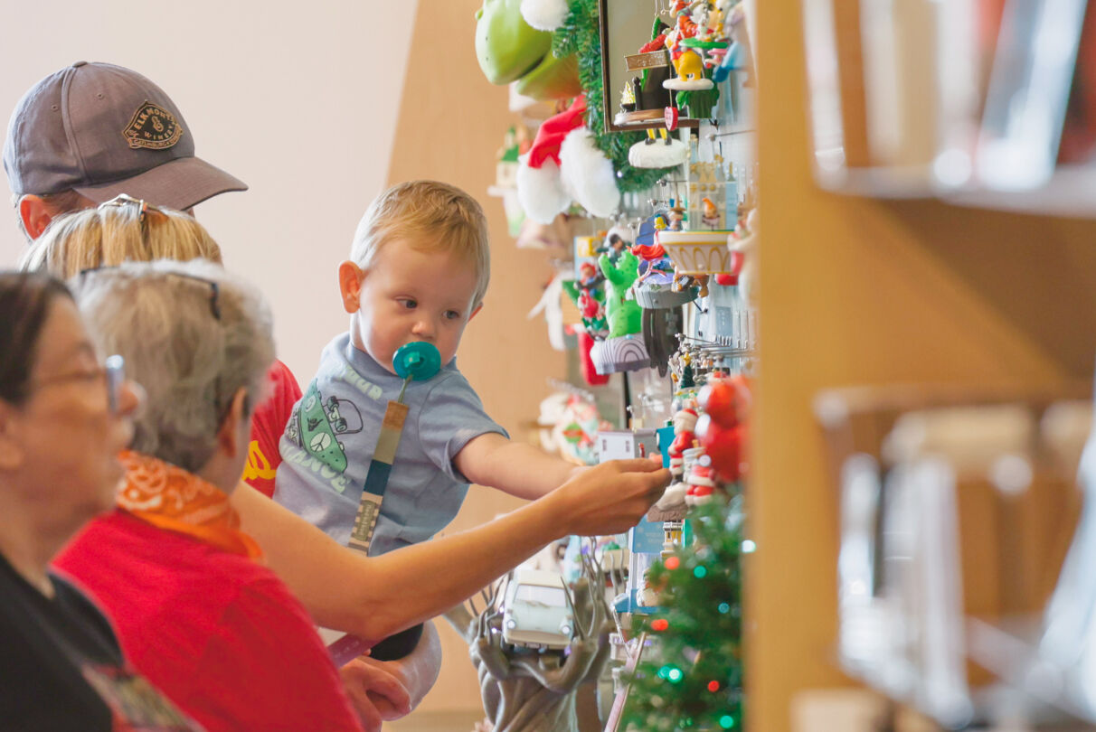 Families looking at the Keepsake Ornament wall in store.