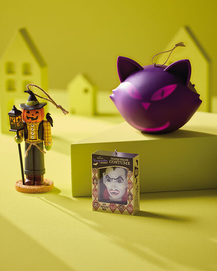 Various Halloween-themed ornaments on an acid green background.