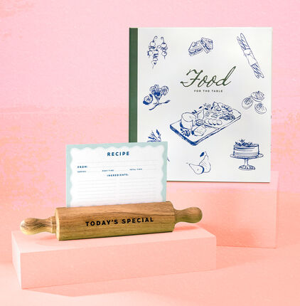 Recipe book, recipe card and wooden rolling pin on orange and pink watercolor background