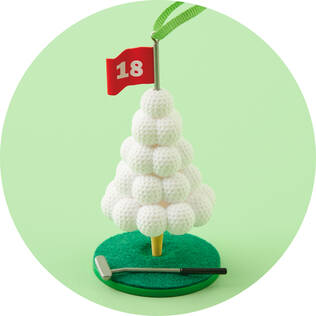 An ornament featuring a Christmas tree made of golf balls with a flag reading "18"