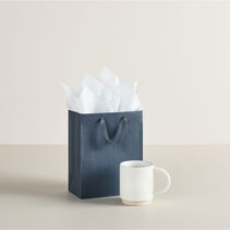 Medium gift bag next to coffee mug. 