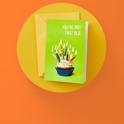 Youre Not That Old Birthday card featuring cupcake with many lit candles on cover.