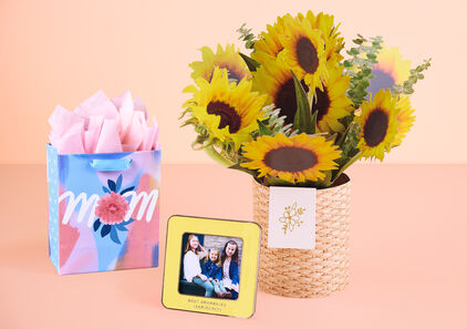 Mother’s Day gift bag, yellow enamel frame that says ‘Best grandkids (seriously)’ and paper vase and sunflowers.