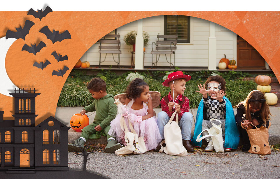 Kids in Halloween costumes sitting on the curb.