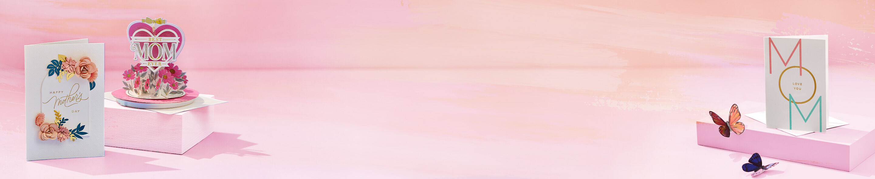 Various Mothers Day cards on a light pink background. 