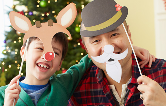 father and boy wearing christmas masks